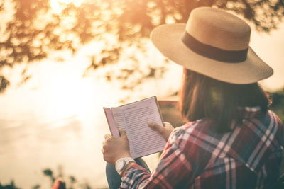 Rear view of couple holding book