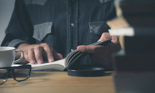 Man using mobile phone while sitting on table