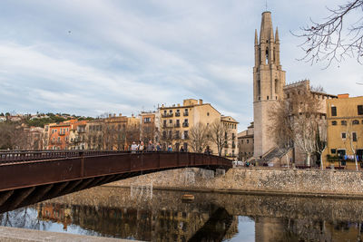 Bridge over river against buildings in city