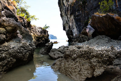 Rock formations by sea against sky