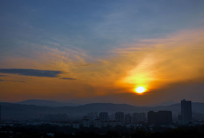 Silhouette buildings against sky during sunset