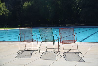Deck chairs at poolside during sunny day