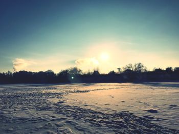 Scenic view of frozen lake against sky during sunset