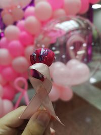 Close-up of woman hand holding pink flowers