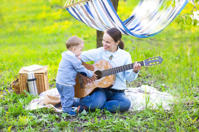 Boy playing guitar on plants