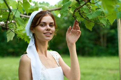 Portrait of young woman holding plant