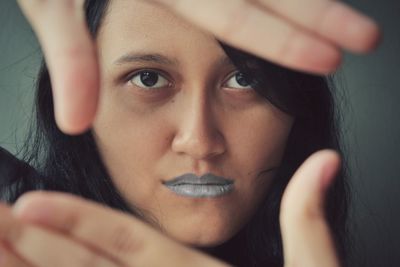 Close-up portrait of young woman gesturing