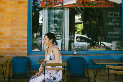 Woman sitting on chair in restaurant