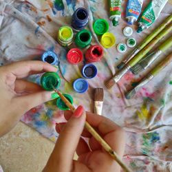 Directly above shot of hands holding multi colored paint