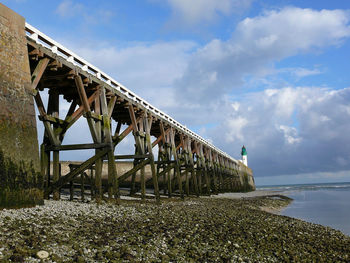 Low angle view of bridge over sea against sky