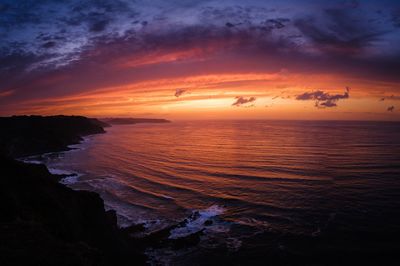 Scenic view of sea against romantic sky at sunset