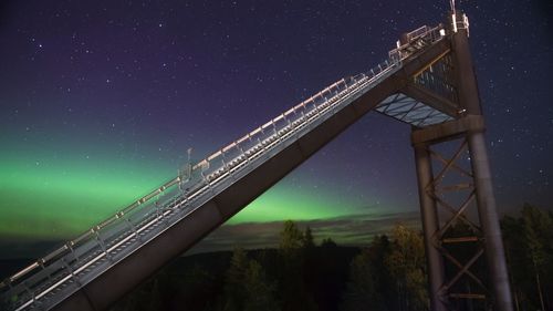 Low angle view of illuminated bridge against sky at night