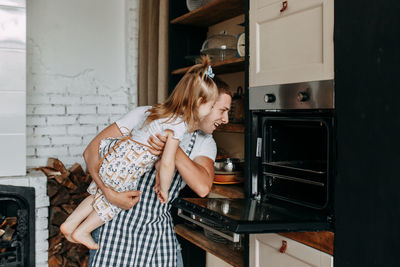 Funny happy dad and daughter baby cook together fool around and play in the kitchen at home