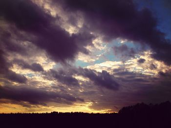 Silhouette of landscape against cloudy sky