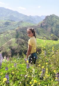 Portrait of girl standing amidst plants on mountain