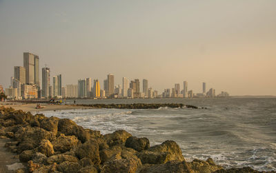 Scenic view of sea and buildings against clear sky