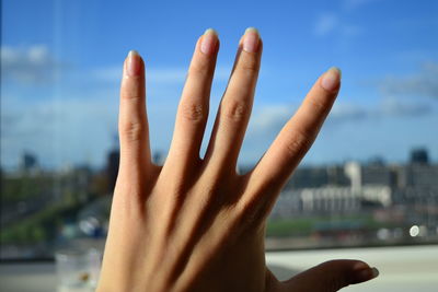 Close-up of hand against sky