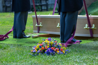 Low section of people standing by flowering plants