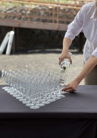 Human hands pouring wine in glasses