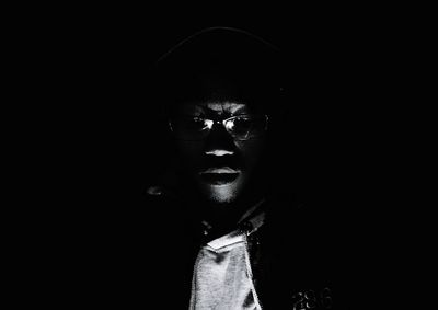 Close-up of young man against black background