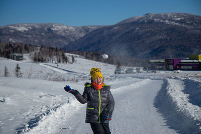 Man standing on snowcapped mountain against sky