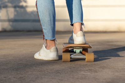 Low section of man skateboarding on road