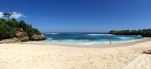 Scenic view of beach against clear blue sky