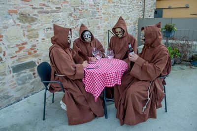Carnival masks disguised as friars while drinking wine