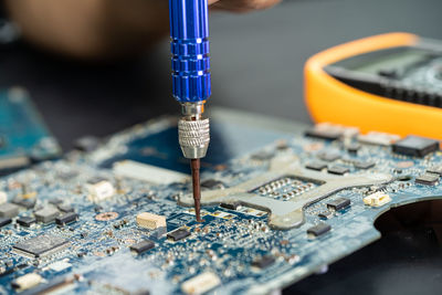 Technician repairing inside of mobile phone. integrated circuit. 