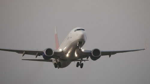 Low angle view of airplane flying against sky