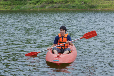 Man sitting on boat in river