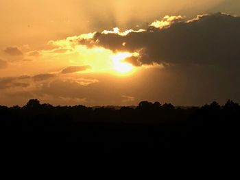 Scenic view of silhouette landscape against orange sky