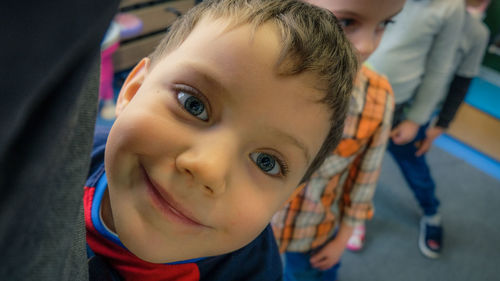 Close-up portrait of boy smiling while standing on floor