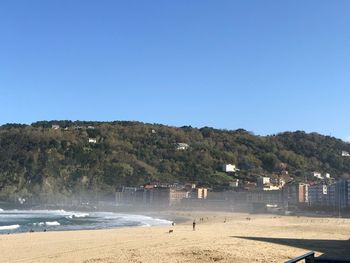 Scenic view of beach against clear blue sky