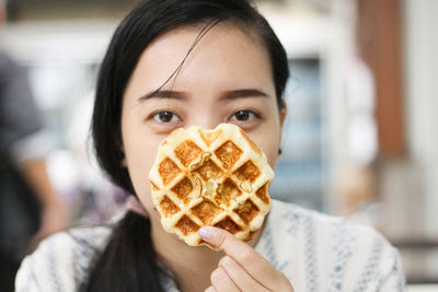 Portrait of woman holding waffle