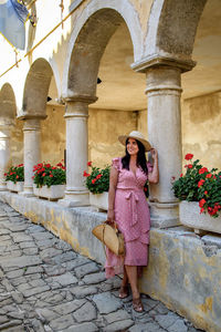 Beautiful young woman in pink dress, summer, old town, picturesque, lifestyle.