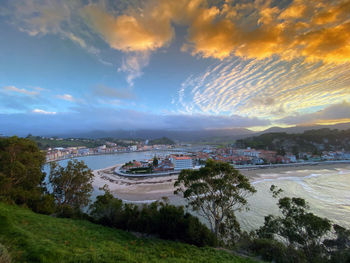 Scenic view of sea and buildings against sky during sunset