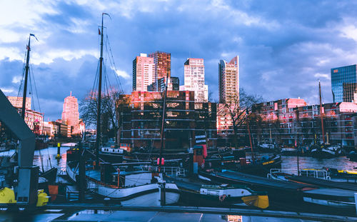 Buildings in city against cloudy sky