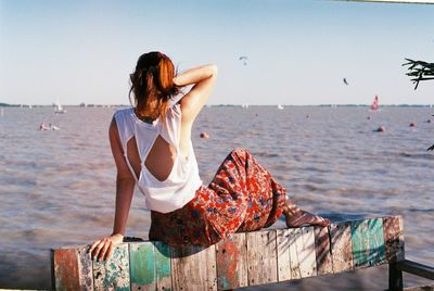 Woman standing at beach against sky
