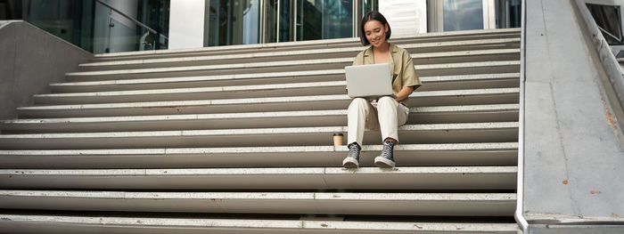 Low angle view of woman standing on staircase