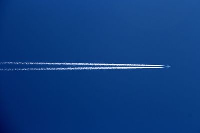 Low angle view of airplane against clear blue sky