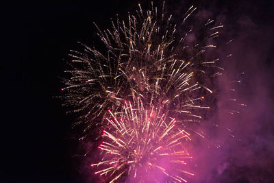 Low angle view of firework display at night