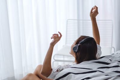 Woman lying down on bed at home