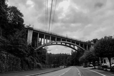 Road by bridge against sky