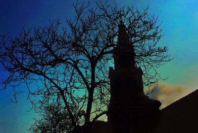 Low angle view of bare trees against blue sky