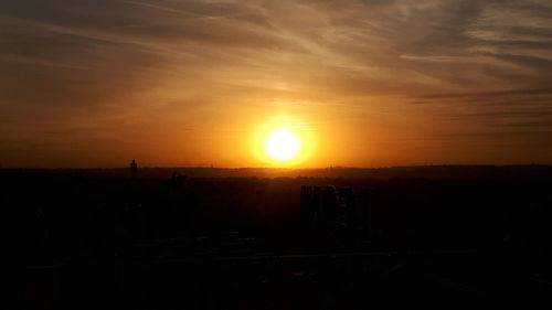 Silhouette cityscape against sky during sunset