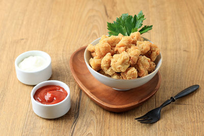 Chicken popcorn on white bowl with spicy sauce and mayonaise