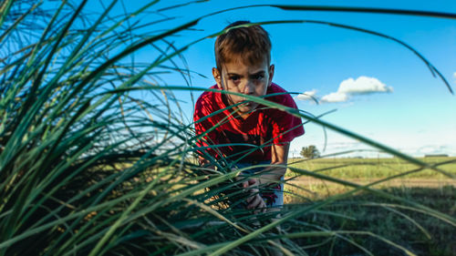 Portrait of boy with umbrella on field