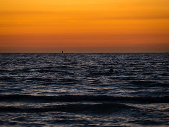 Scenic view of sea against orange sky