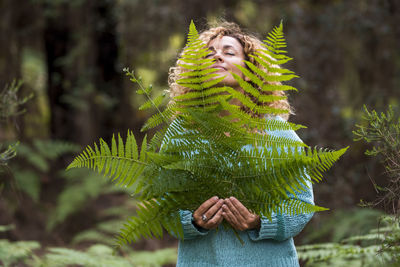 Midsection of woman holding plant